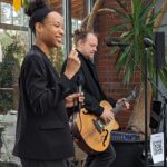 Foto vom Duo Tom und Lily. Tom spielt Gitarre, Lily singt.